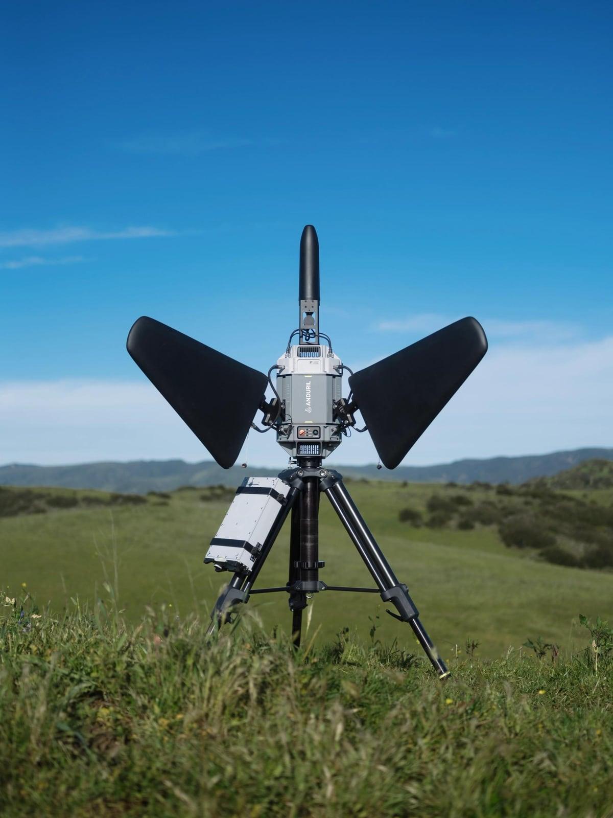 Pulsar on a tripod in a grassy field under a clear blue sky